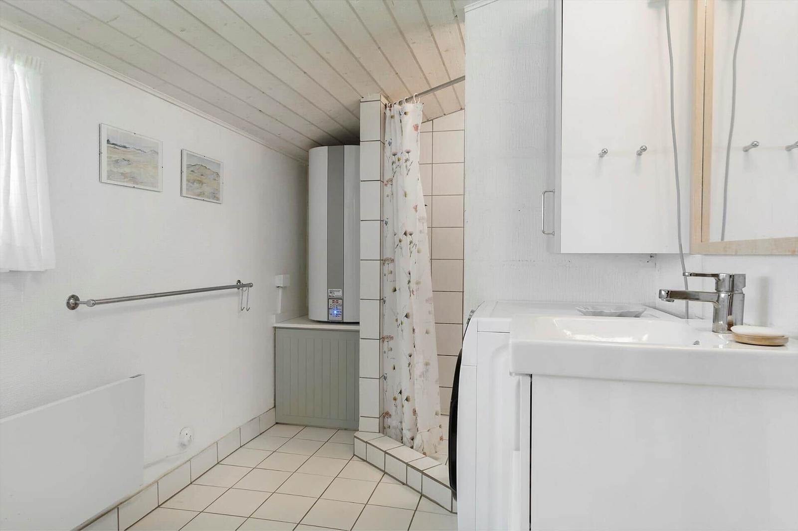 Bathroom with shower, sink, and heater.