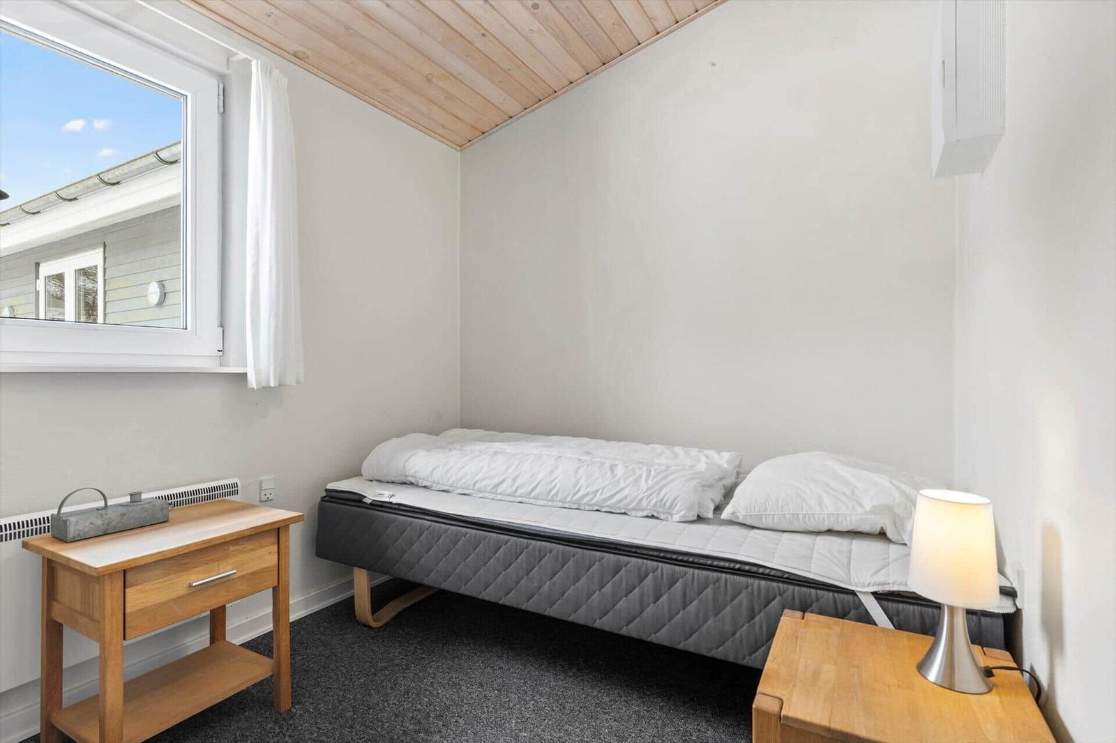 Bedroom with bed, nightstand, and window.