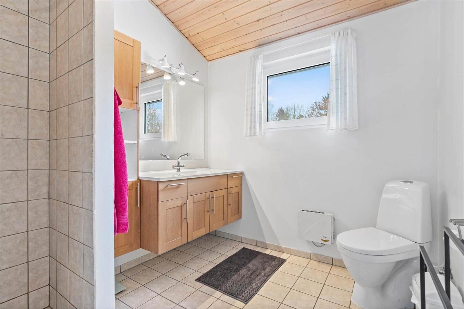 Bathroom with sink, toilet, and window
