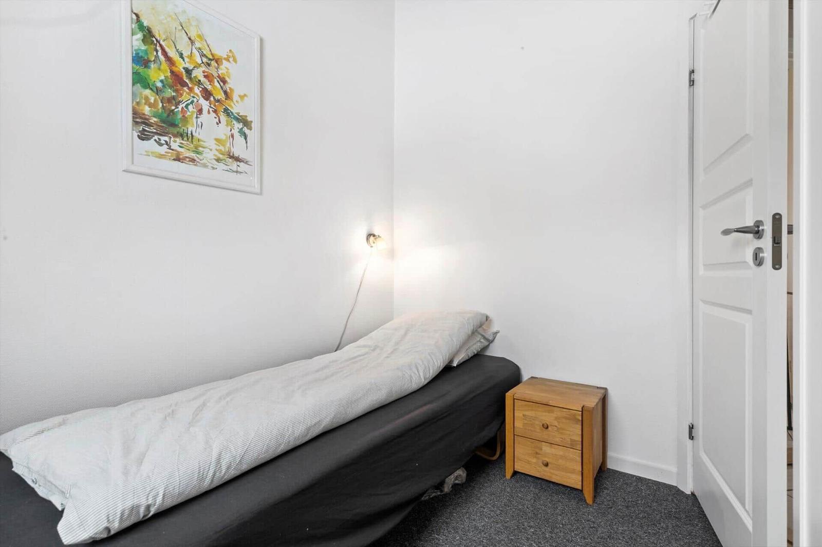 Bedroom with bed, nightstand, and wall art.