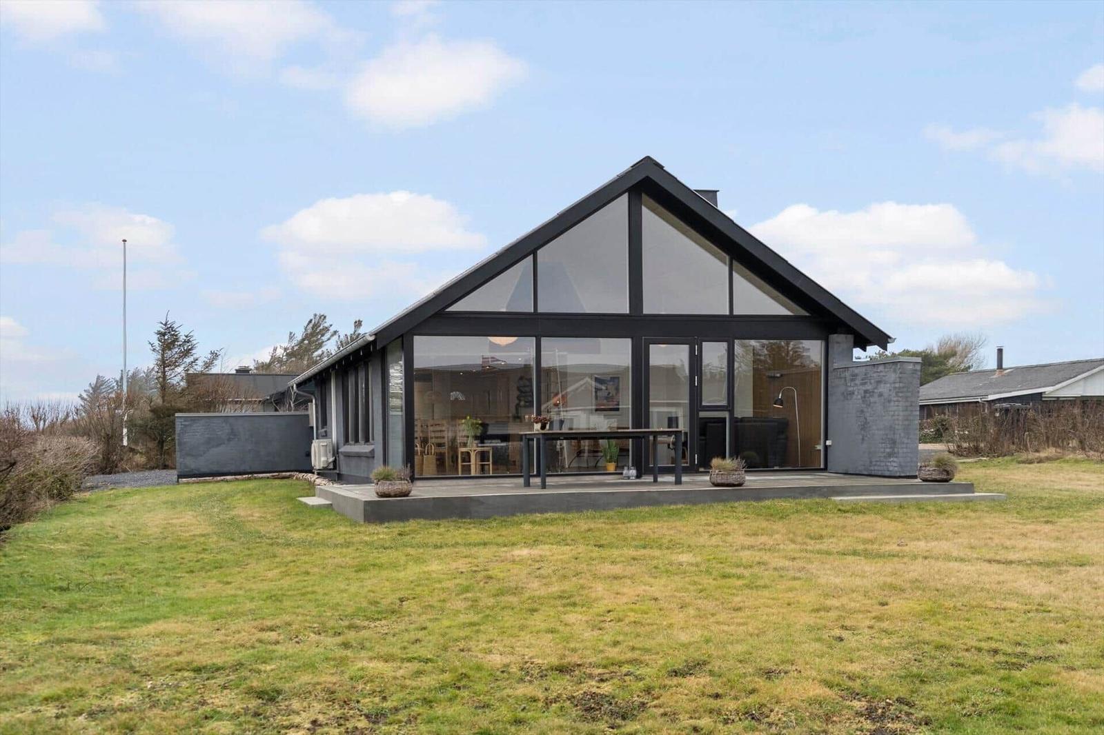 Moderne Villa mit großem Glasbereich und Terrasse im Freien.