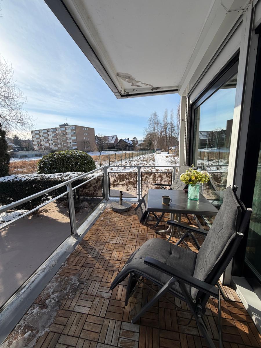 Terrasse mit Tisch, Stühlen und Blick auf Wohngebiet