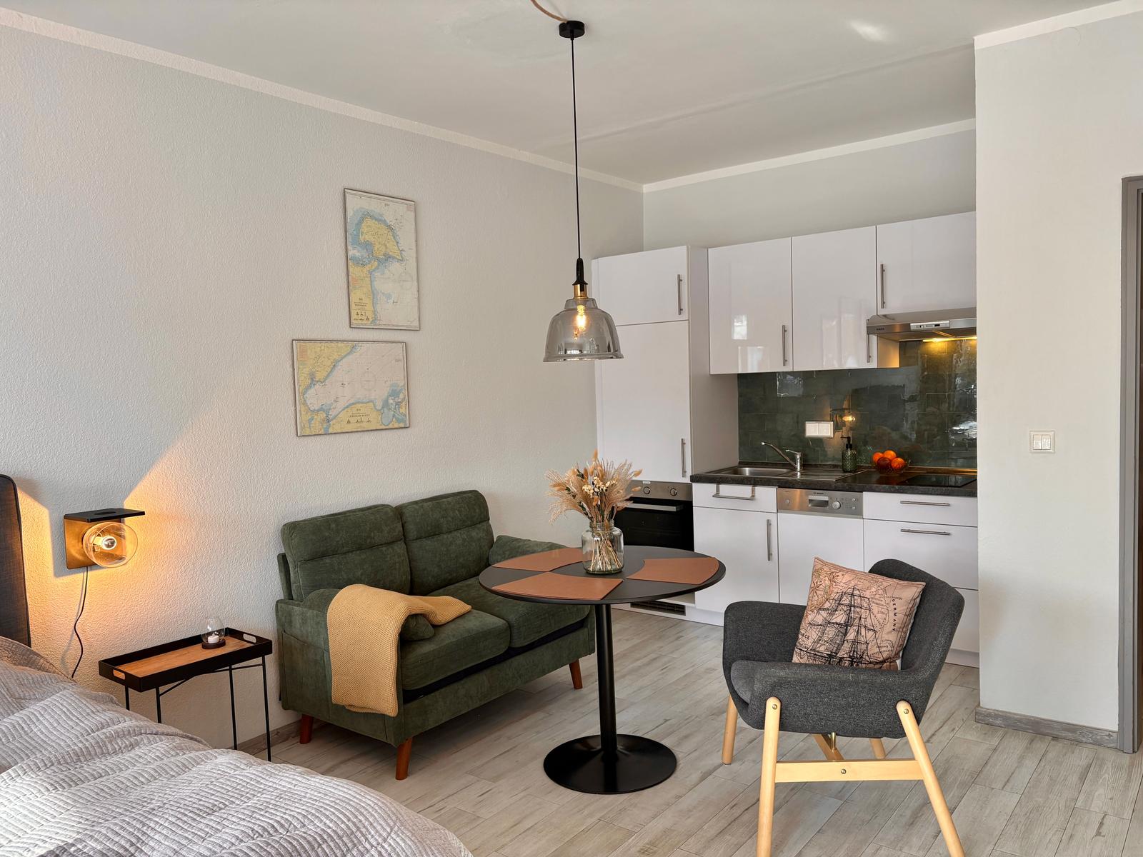 Wohnbereich mit Sofa, Esstisch und Küche