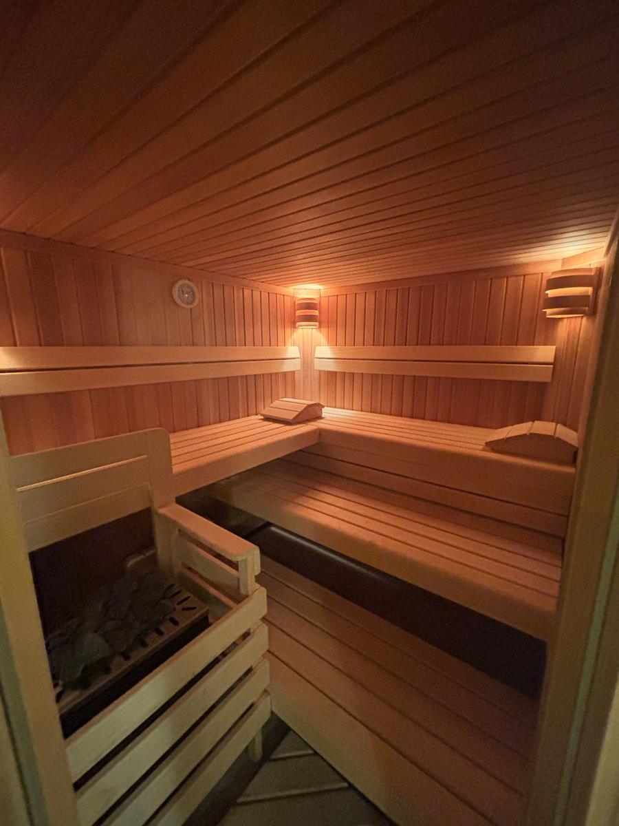 Sauna mit Holzbanken und Heizung im Innenraum.