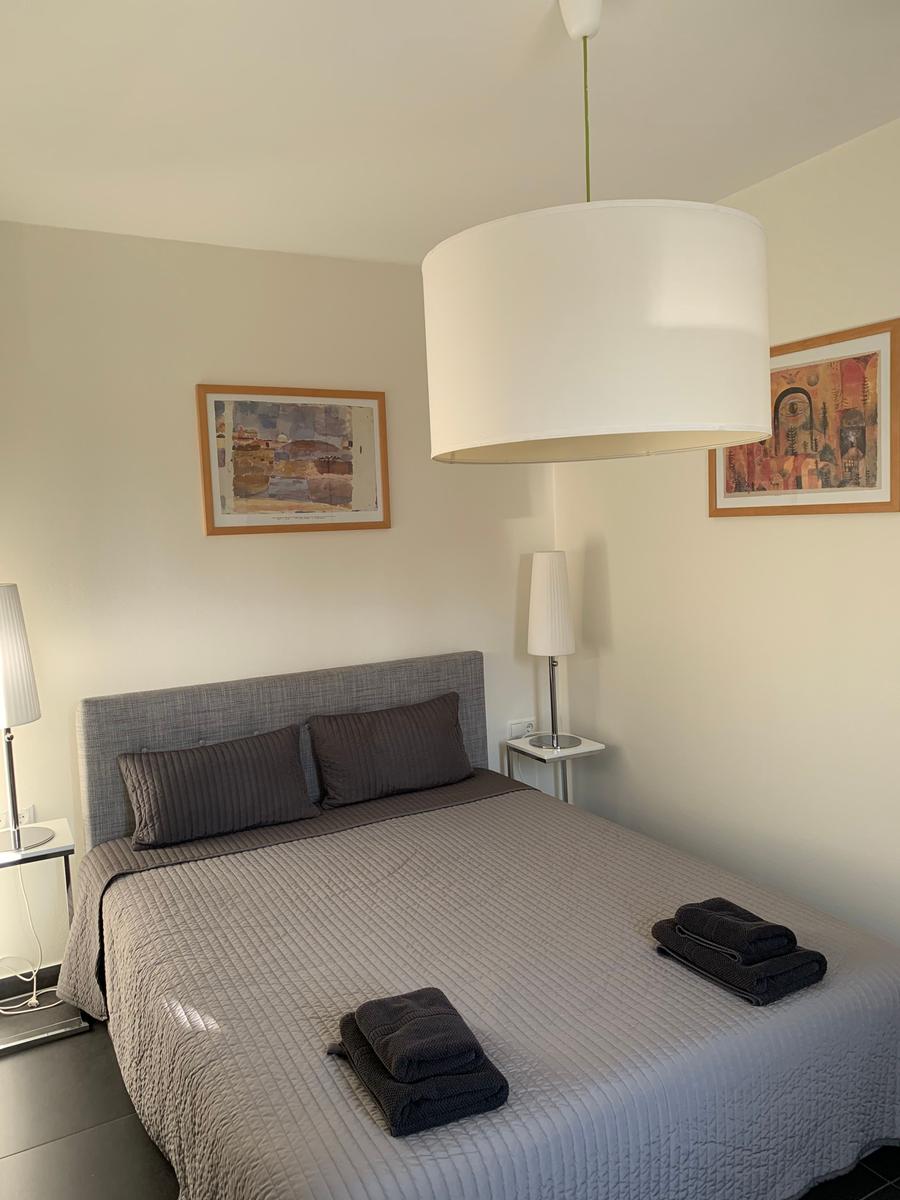 Schlafzimmer mit Bett, Nachttischen und Decken.