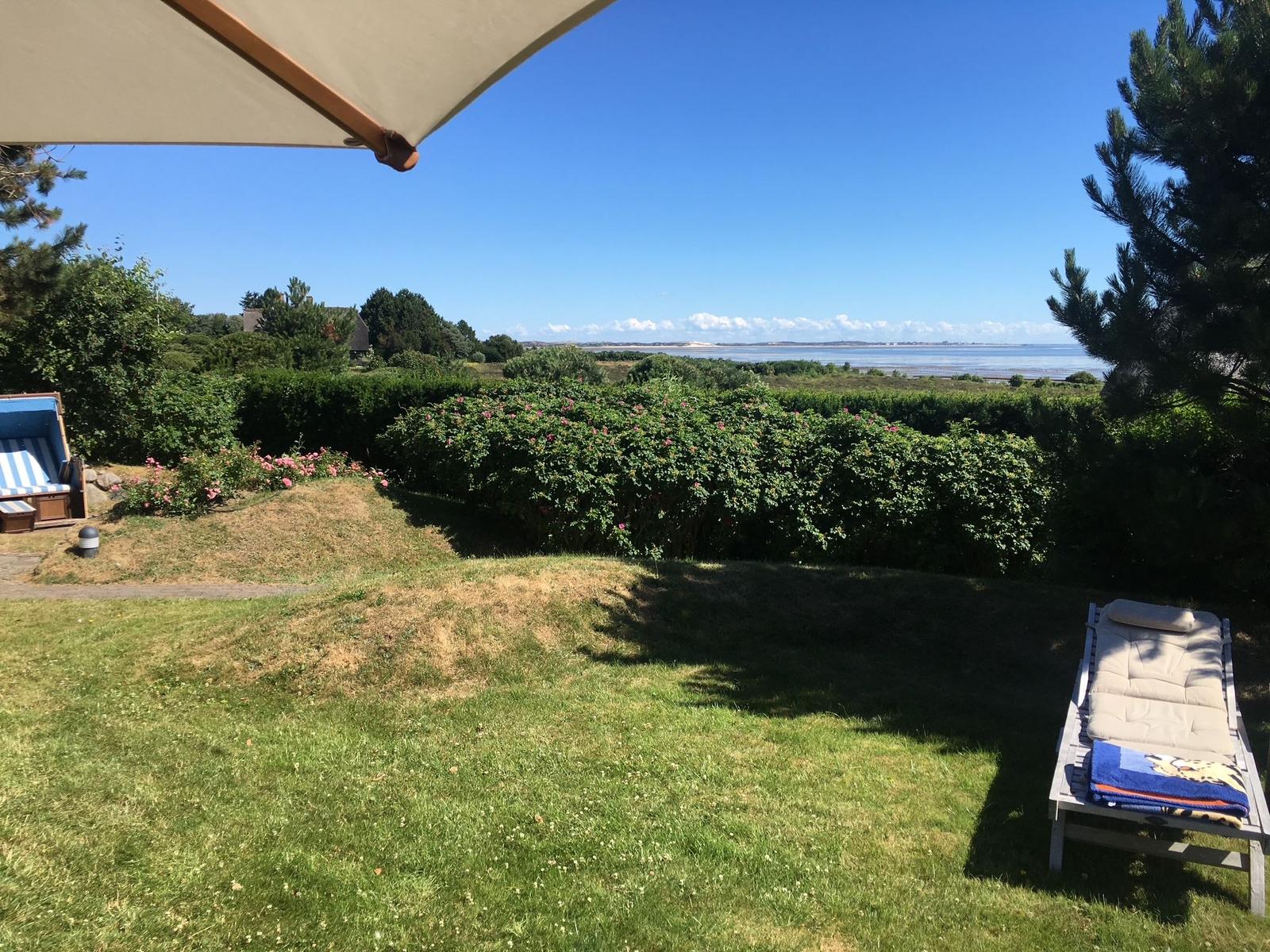 Garten mit Liegestühlen und Blick aufs Wasser
