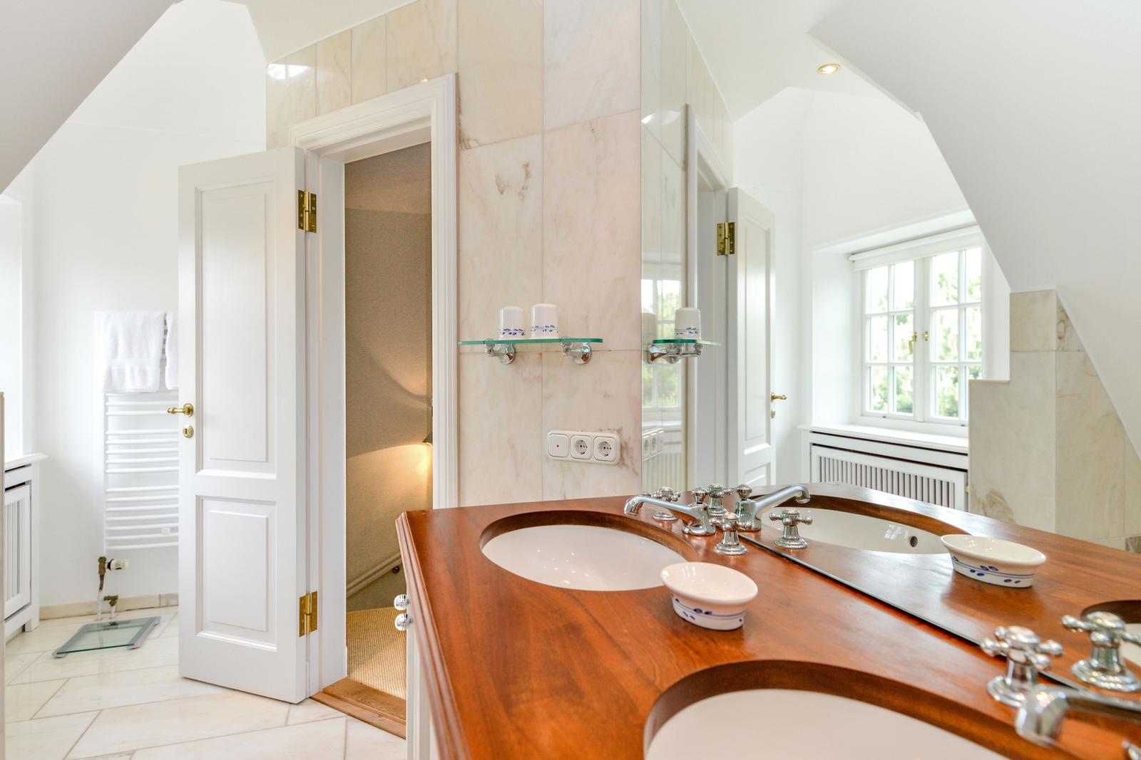 Badezimmer mit Holzwaschtisch, Spiegel und Dusche