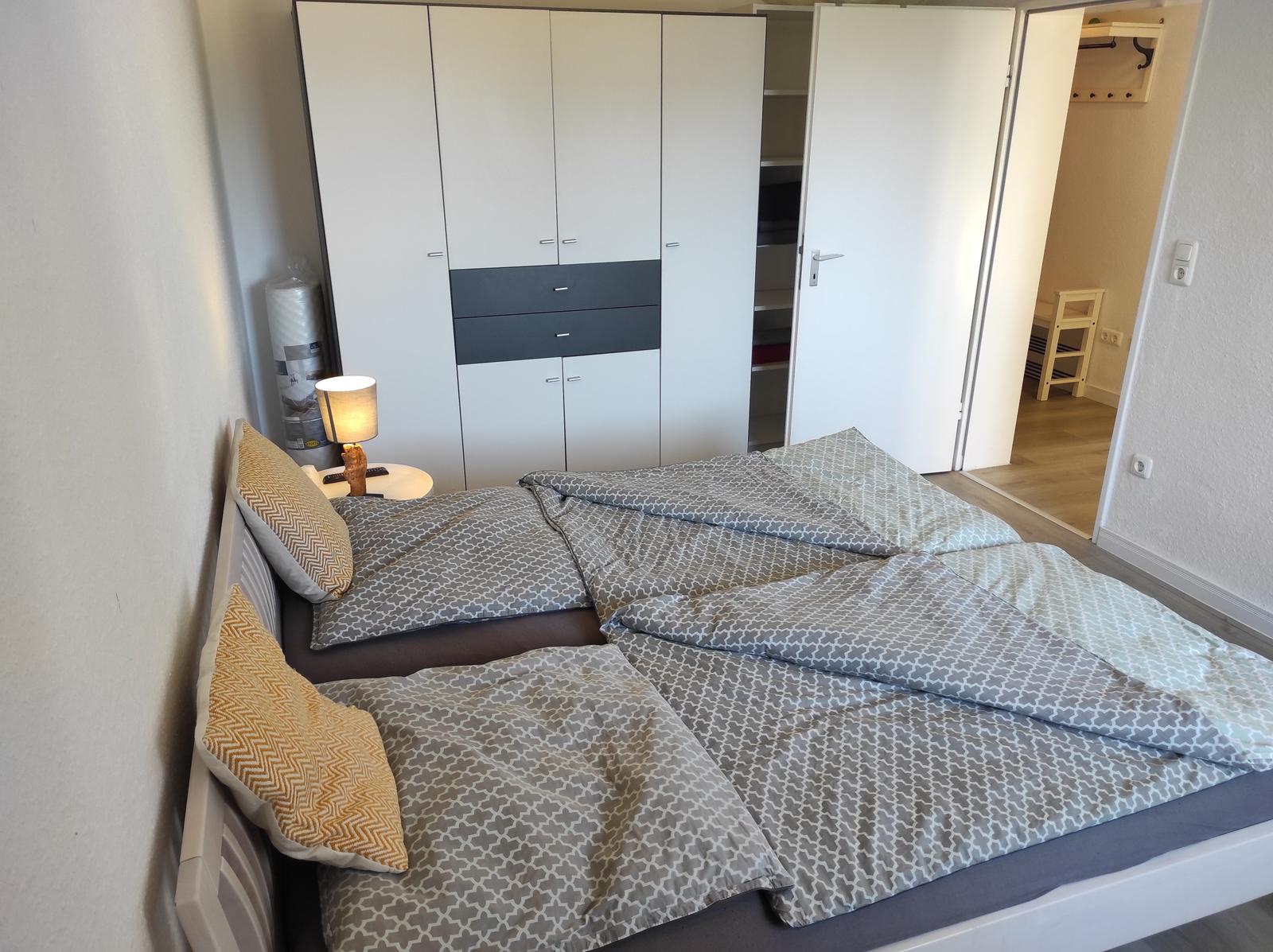 Schlafzimmer mit Doppelbett, Kleiderschrank und Nachttisch.