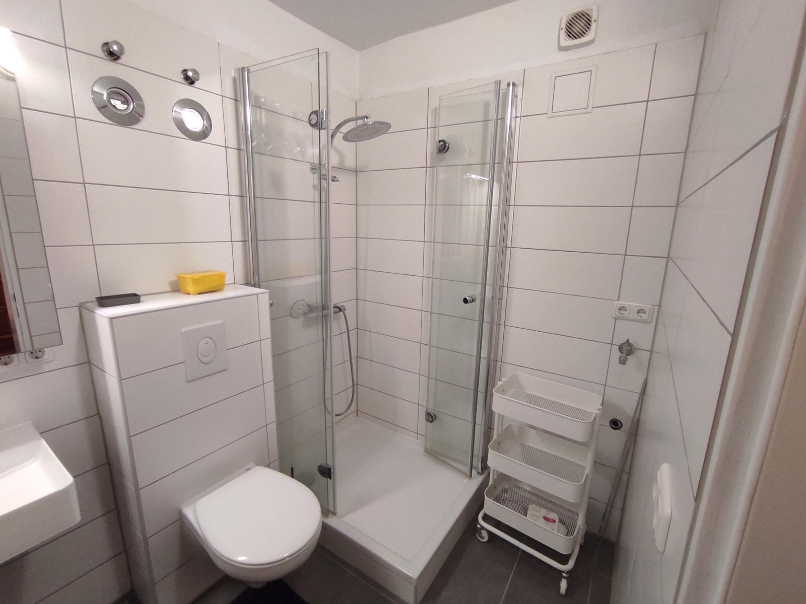 Badezimmer mit Dusche, Toilette und Waschbecken