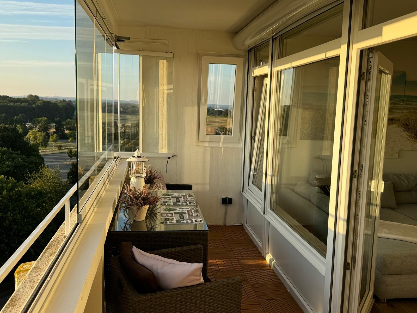 Terrasse mit Sitzgruppe und Blick auf Landschaft.