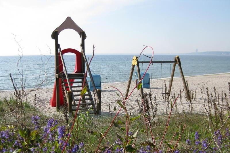 Kinderspielplatz mit Rutsche und Schaukel am Strand