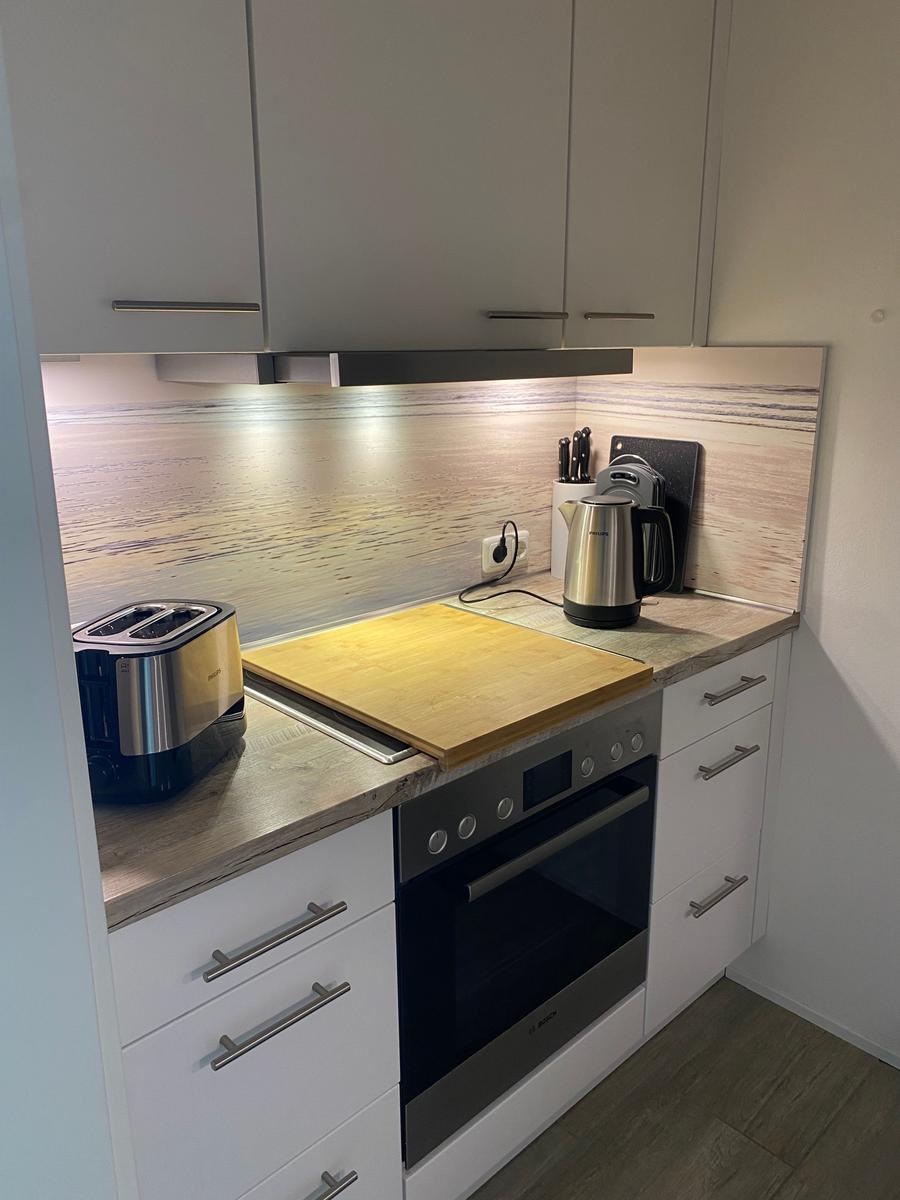 Küche mit Dunstabzug, Herd und Arbeitsfläche