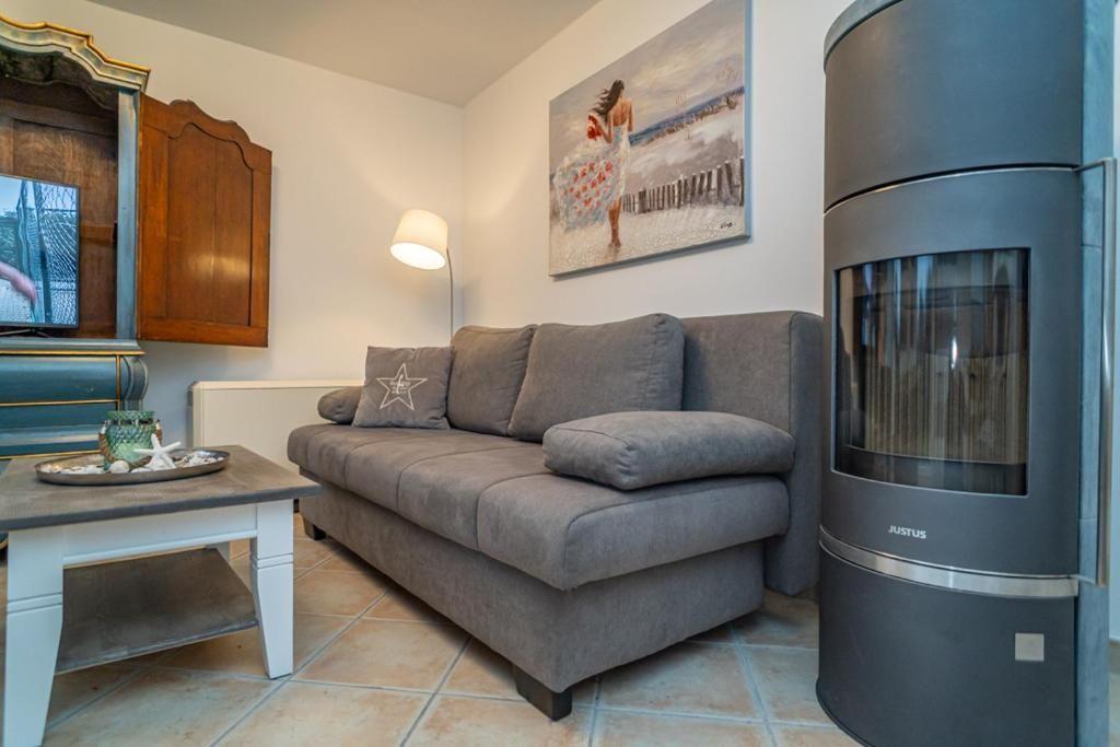 Wohnzimmer mit Sofa, Kamin und Fernseher.