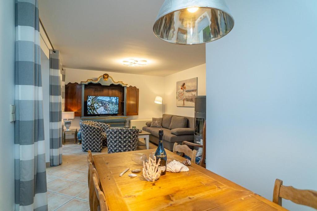 Essbereich mit Holztisch und Sitzgelegenheiten im Wohnzimmer mit Fernseher und Kamin.