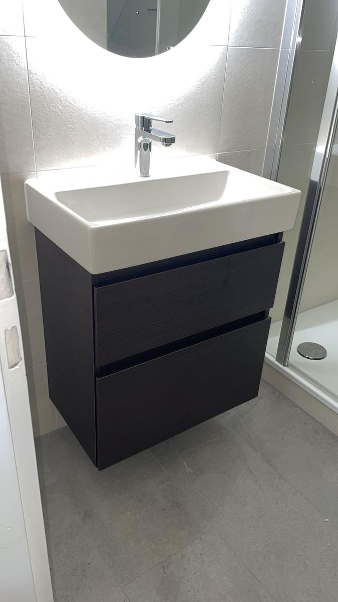 Waschbecken mit Spiegelschrank und Duschbereich