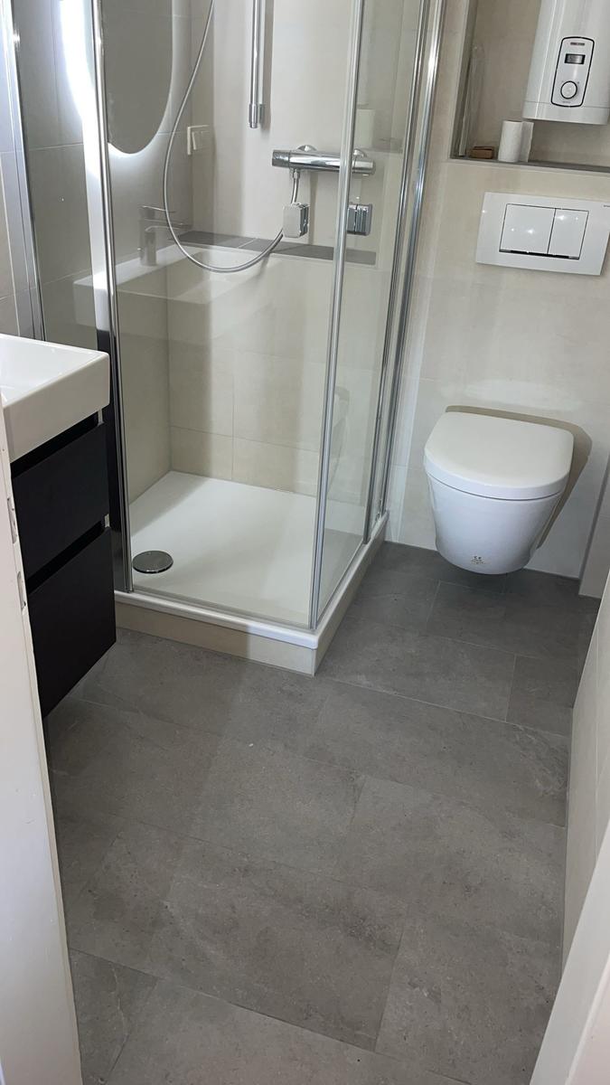 Badezimmer mit Dusche, Toilette und Waschbecken