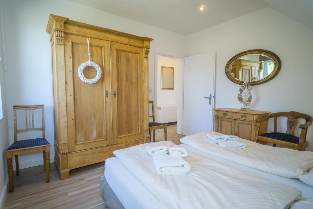 Schlafzimmer mit Bett, Holzschrank und Spiegelschrank.