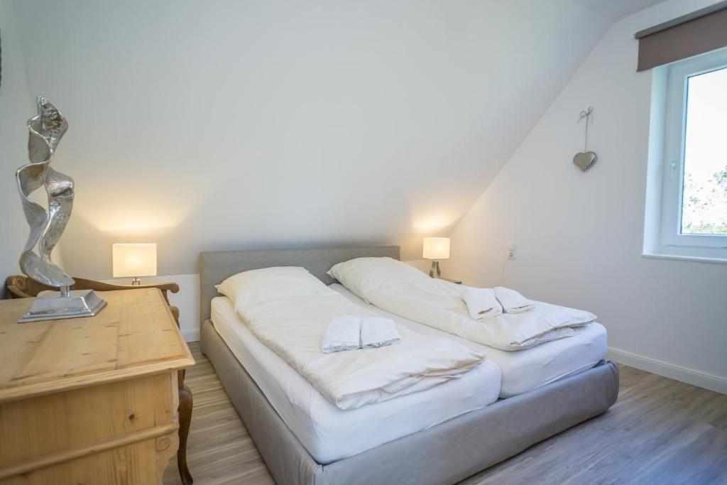 Schlafzimmer mit Doppelbett, Nachttischen und Fenster.