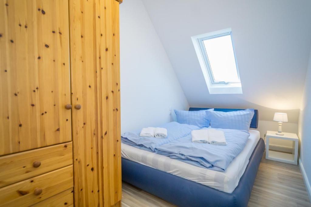Schlafzimmer mit Dachschrägen, Holzschrank und Dachfenster.