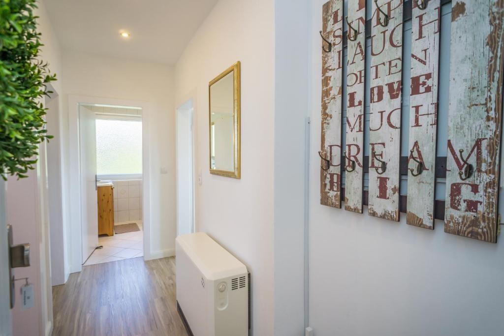 Flur mit Holzboden, Spiegel und Wanddekoration mit Haken.