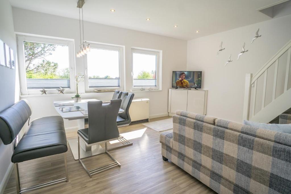 Wohn- und Essbereich mit Sofa, Esstisch und TV.