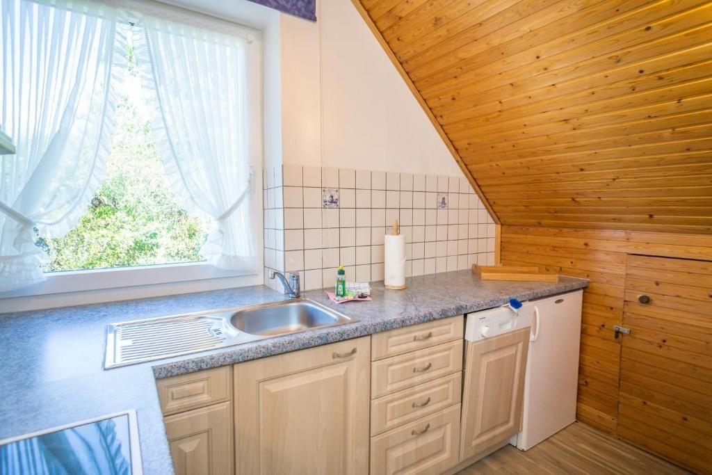 Küche mit Spüle, Fenster und Holzdecke