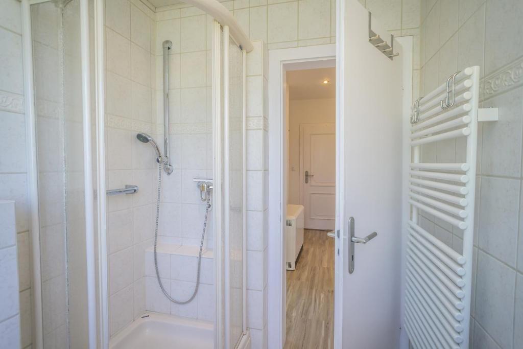 Duschkabine mit Handbrause und Heizkörper an der Wand