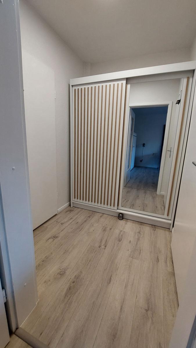 Schlafzimmer mit Schiebetüren und Holzboden