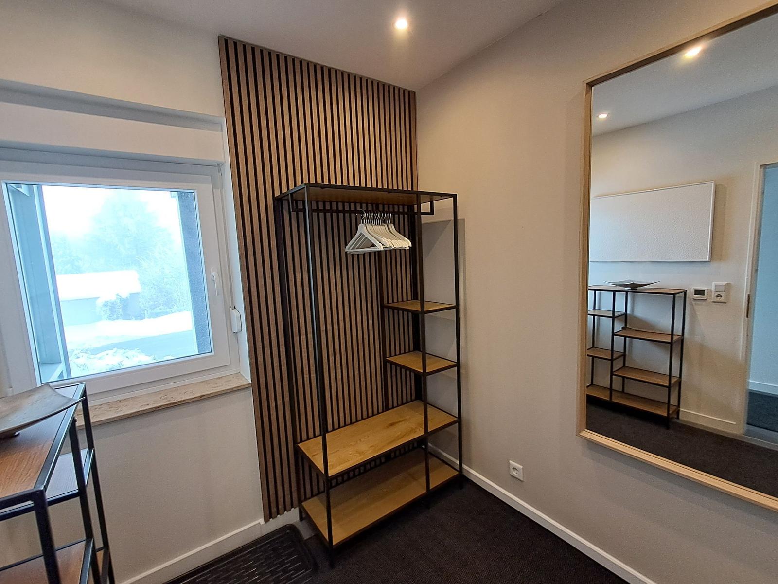 Schlafzimmer mit Kleiderschrank, Spiegel und Fenster