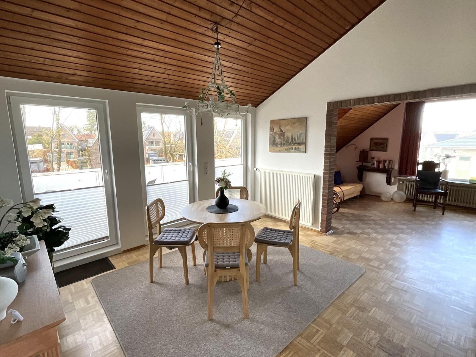Essbereich mit Tisch, Stühlen und Fenstern. Hinterhofbereich mit Sitzgelegenheit.