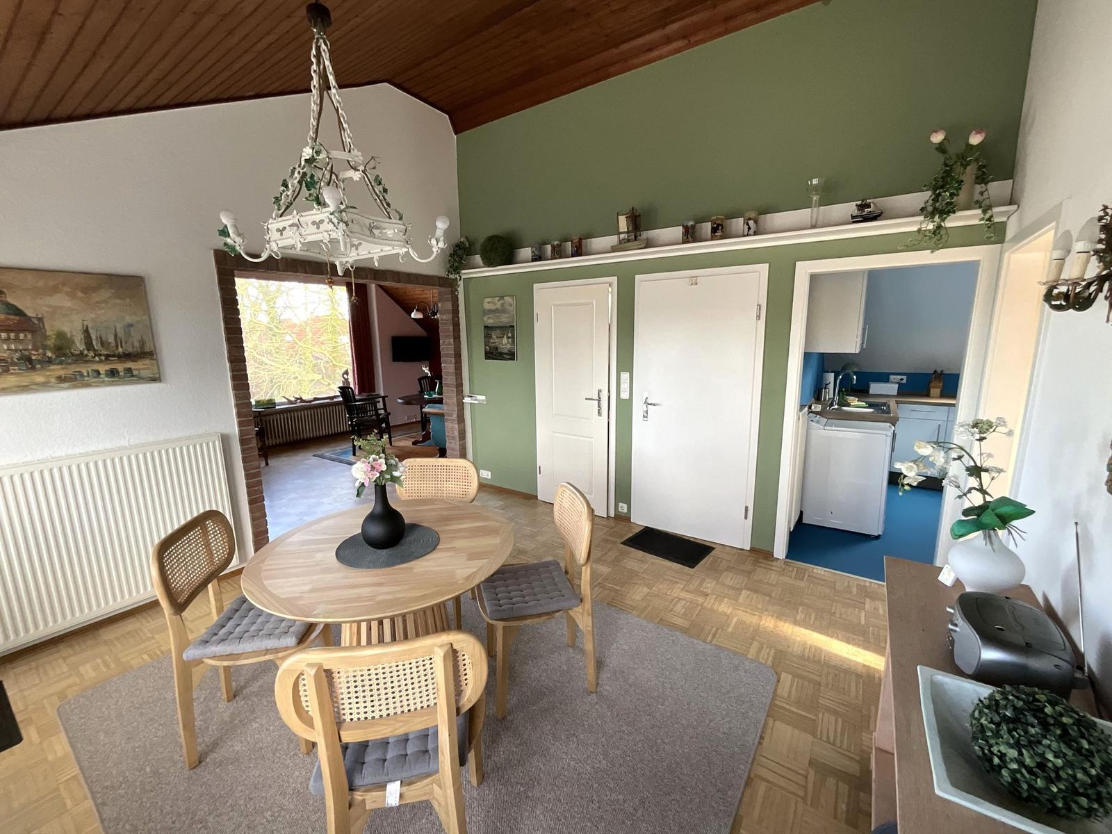 Essbereich mit Tisch, Stühlen und Deckenventilator. Küche und Schlafzimmer im Hintergrund.