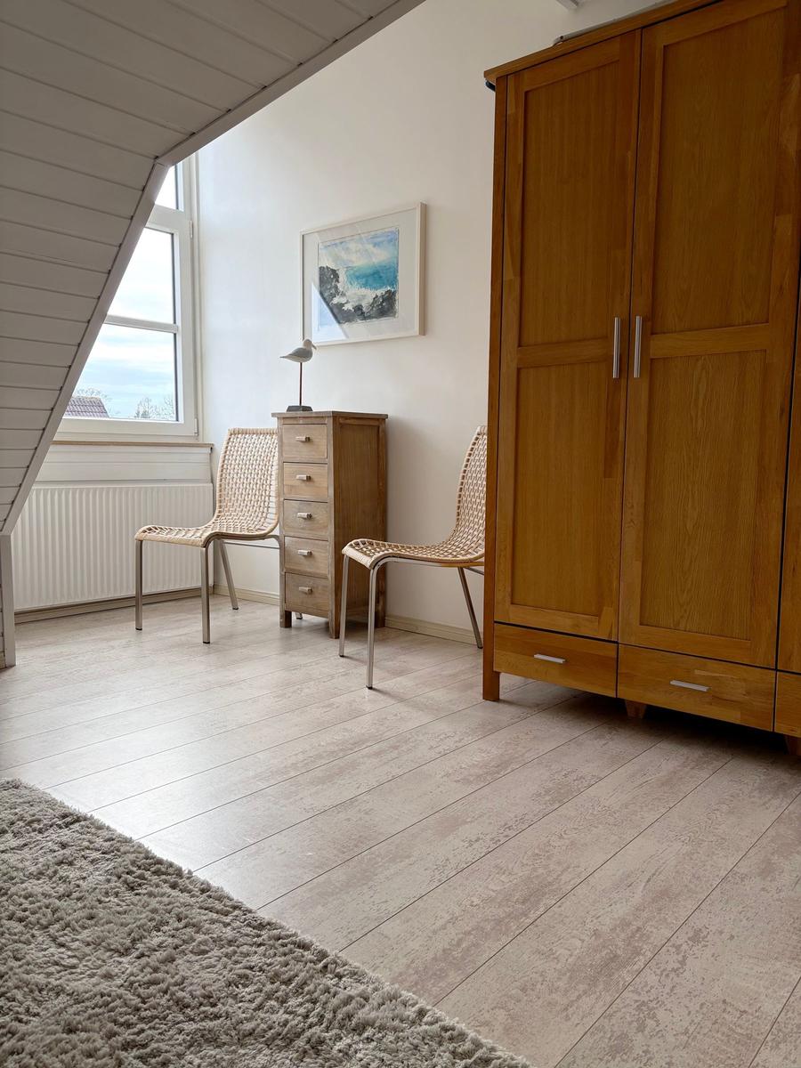 Zimmer mit Holzmöbeln, Fenster und Teppichboden