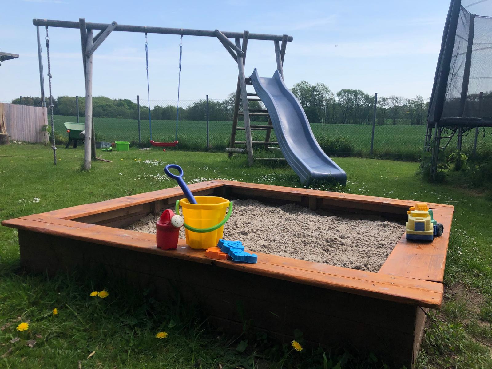Unsere Sandkiste mit Rutsche und Schaukel