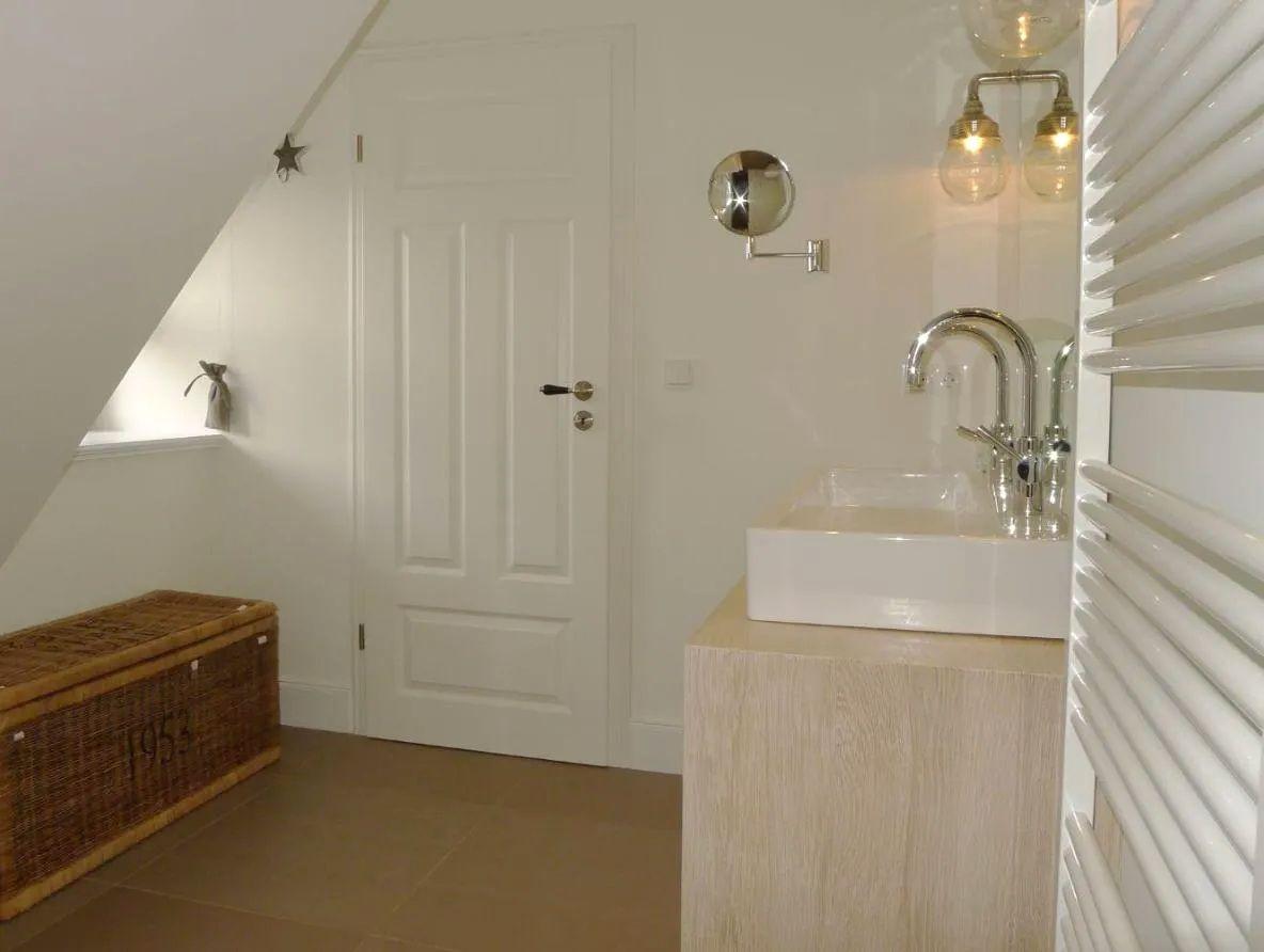 Badezimmer mit Waschbecken, Spiegel und Heizkörper