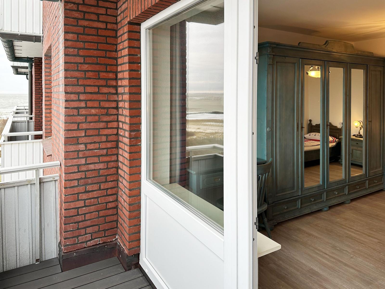 Rotes Ziegelhaus mit Blick aufs Meer. Blick in Schlafzimmer mit großer Garderobe.