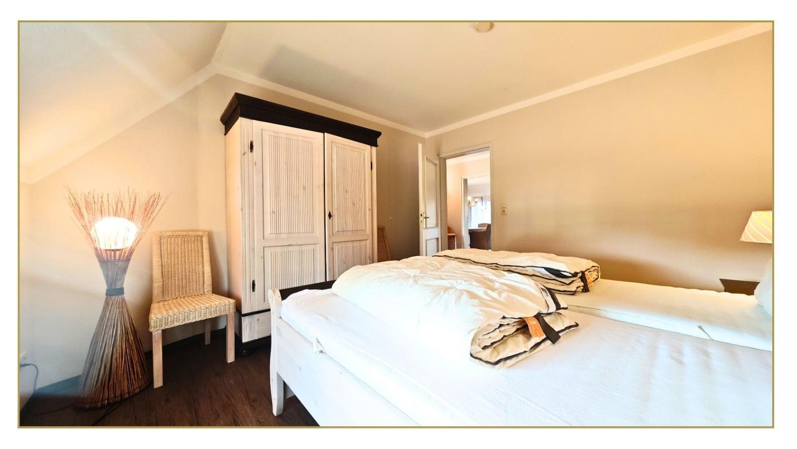 Schlafzimmer mit Bett, Kleiderschrank und Stuhl.