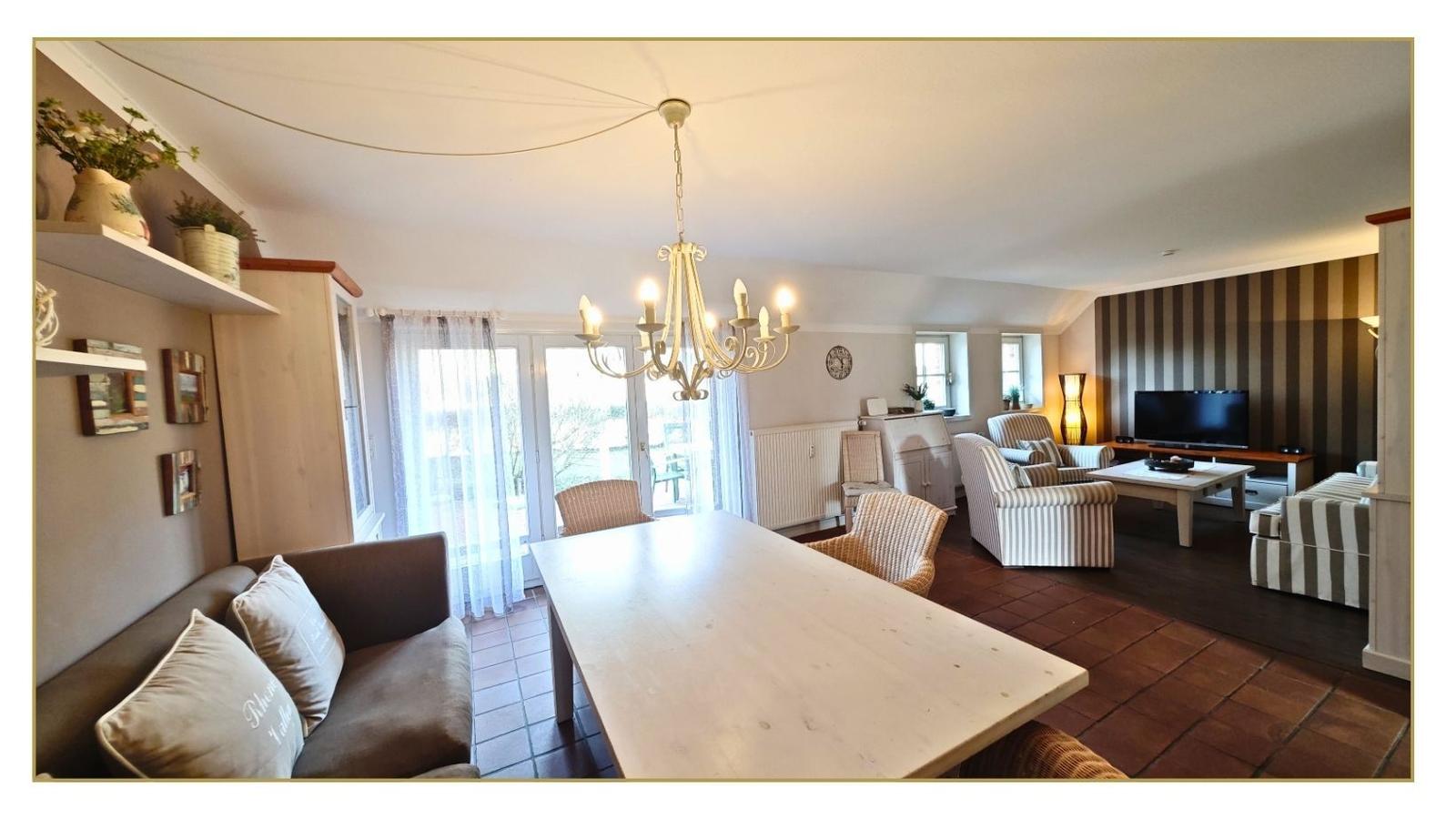 Wohn- und Essbereich mit Esstisch, Sofa und Fernseher.