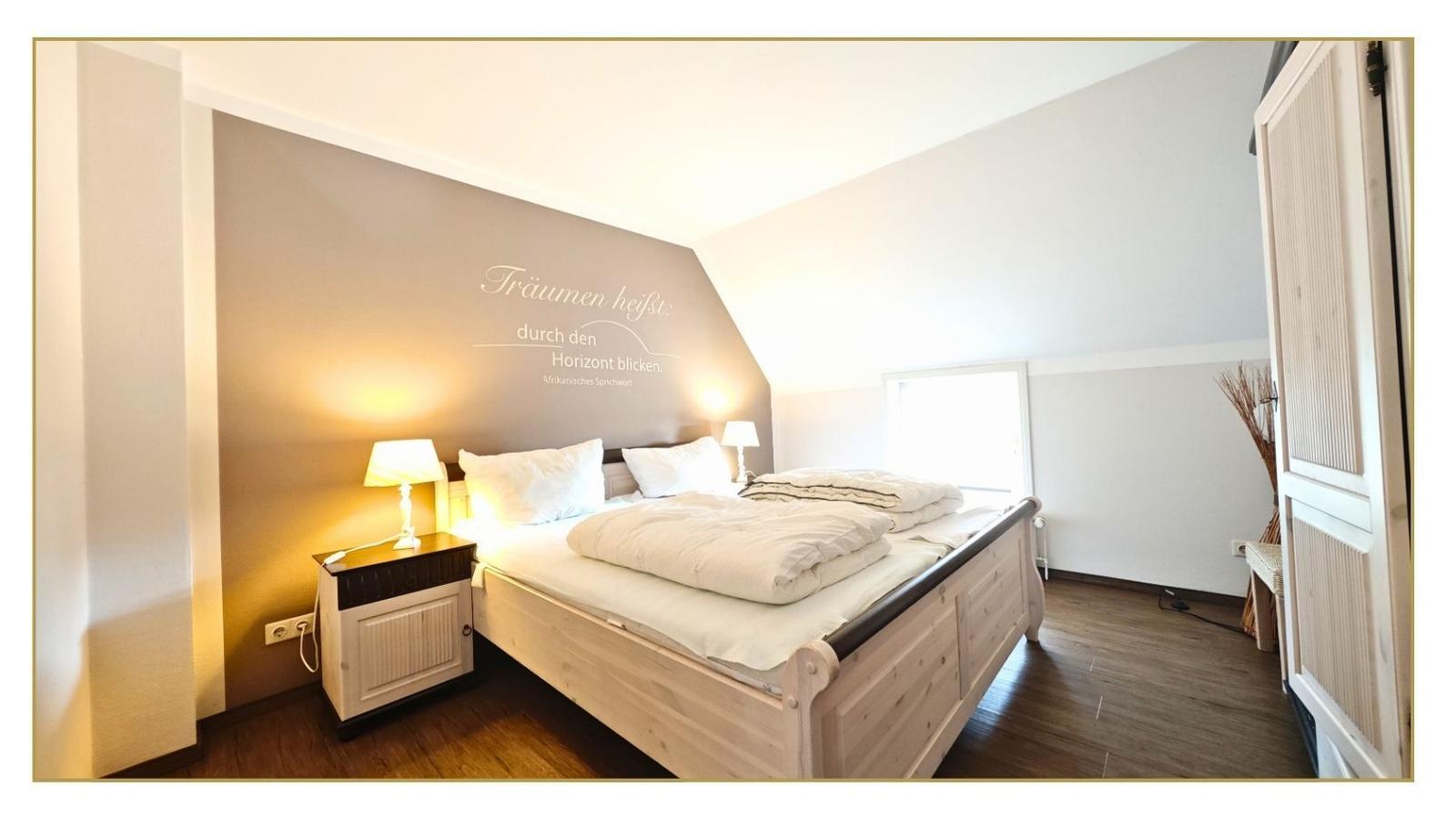 Schlafzimmer mit Bett, Nachttisch und Wanddekoration.