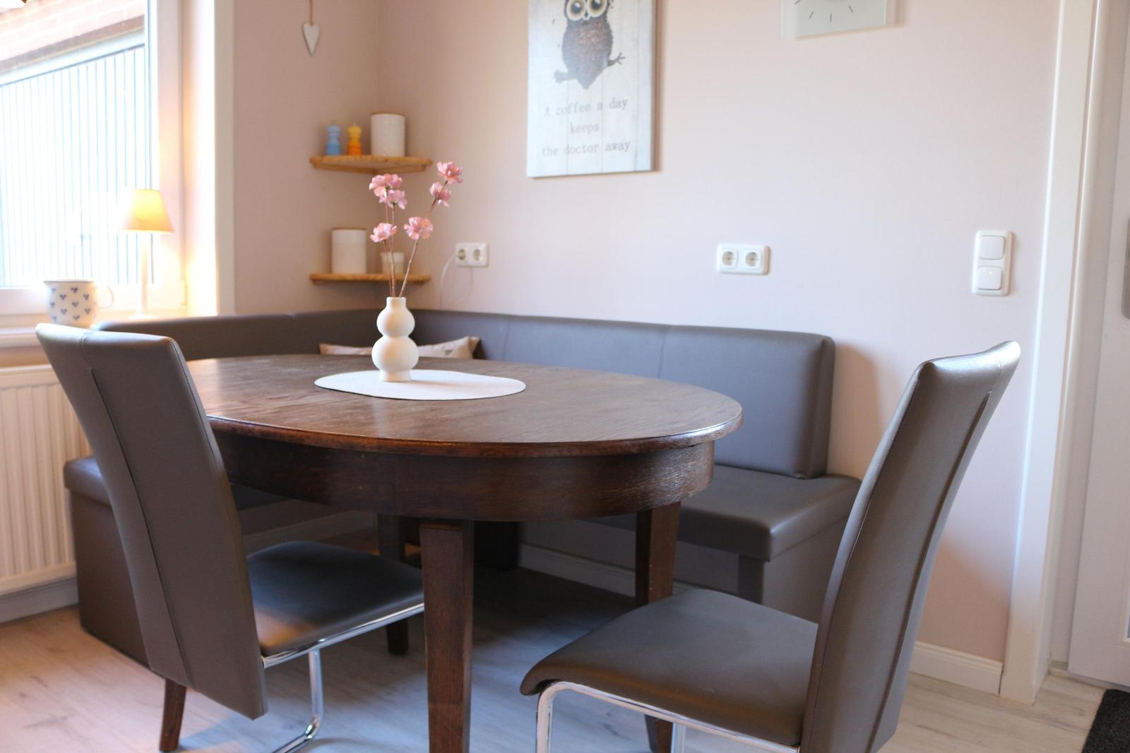 Runde Holztisch mit Stühlen und Sitzbank an der Wand