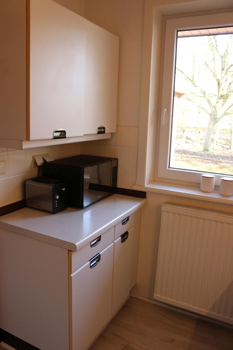 Küche mit Mikrowelle, Toaster und Fenster