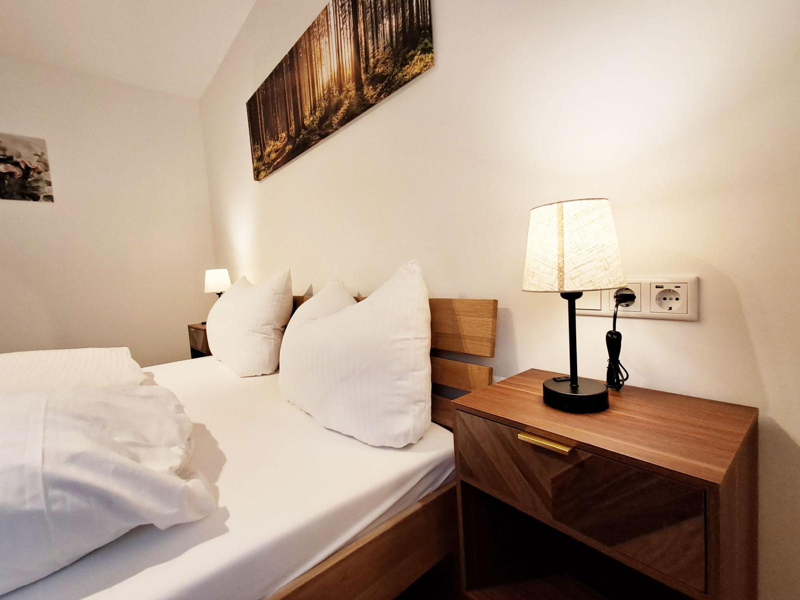 Schlafzimmer mit Bett, Nachttisch und Wandbild