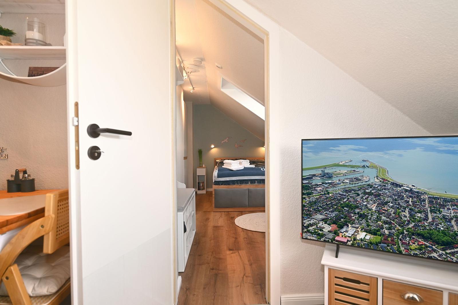 Schlafzimmer mit Dachschrägen und TV mit Stadtansicht