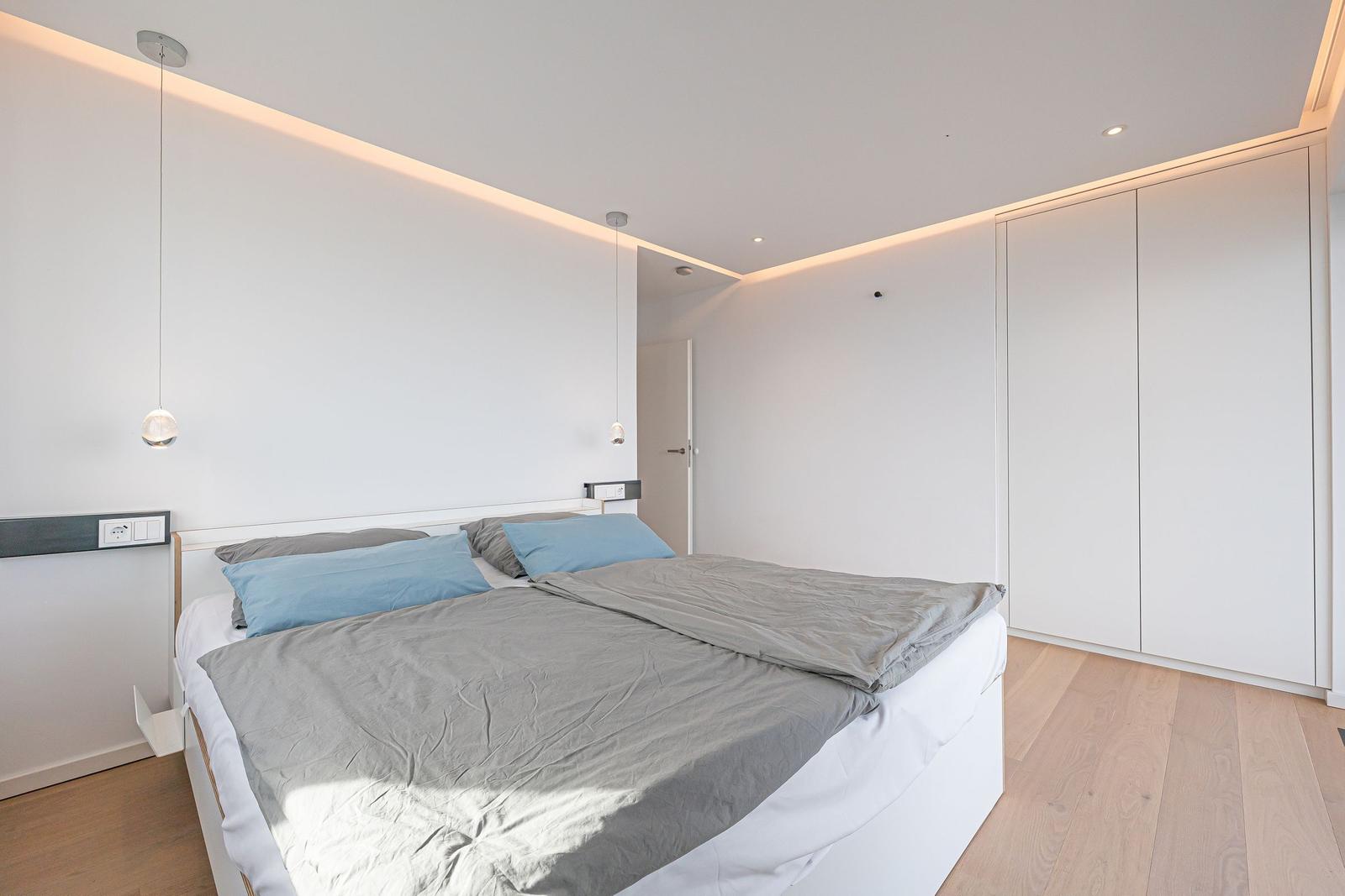 Schlafzimmer mit Doppelbett, Kleiderschrank und Holzboden.