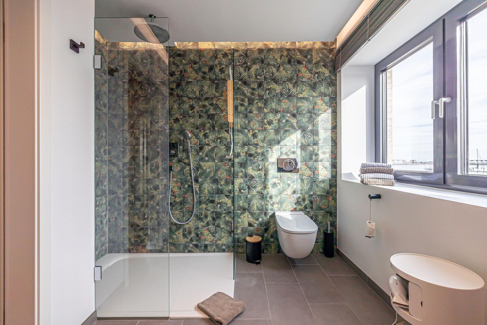 Bad mit Dusche, Toilette und Fenster mit Blick.