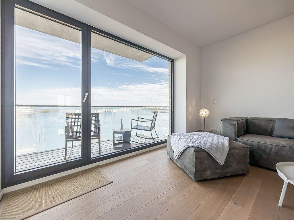 Wohnzimmer mit Balkon und Meerblick. Sofa, Sessel und Tisch sind vorhanden.