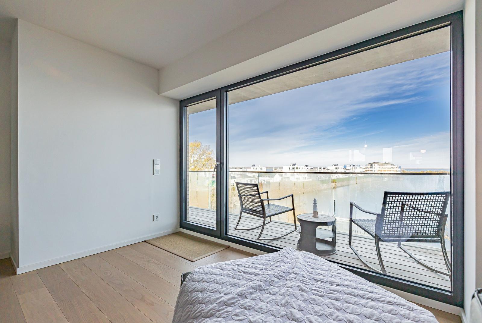 Schlafzimmer mit Balkon und Blick auf Wasser