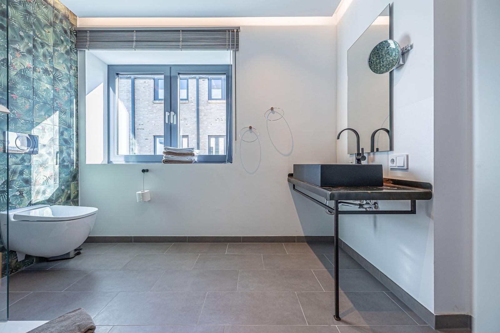 Badezimmer mit Dusche, Waschbecken und Fenster