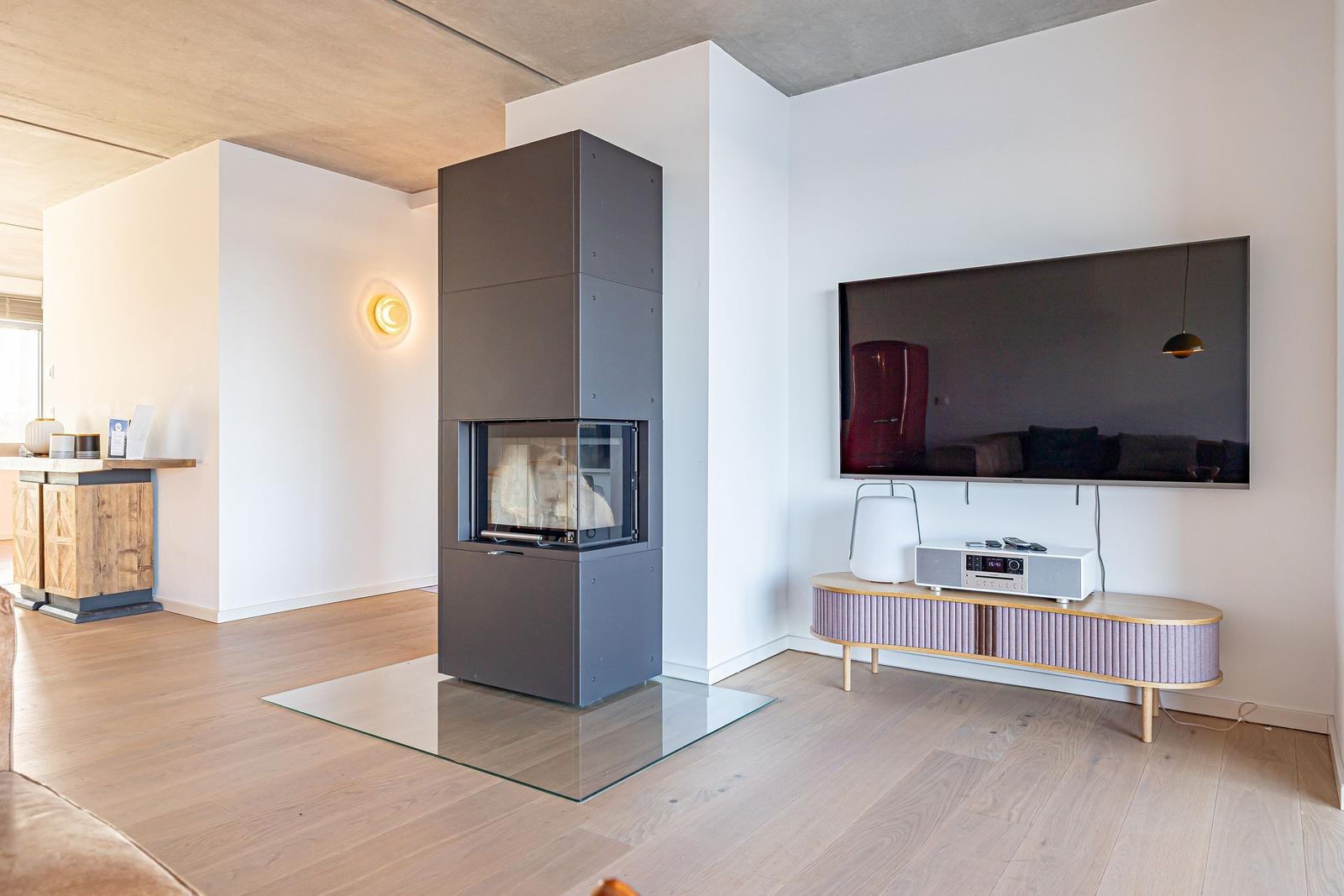 Moderne Wohnfläche mit Kamin, Fernseher und TV-Möbel.