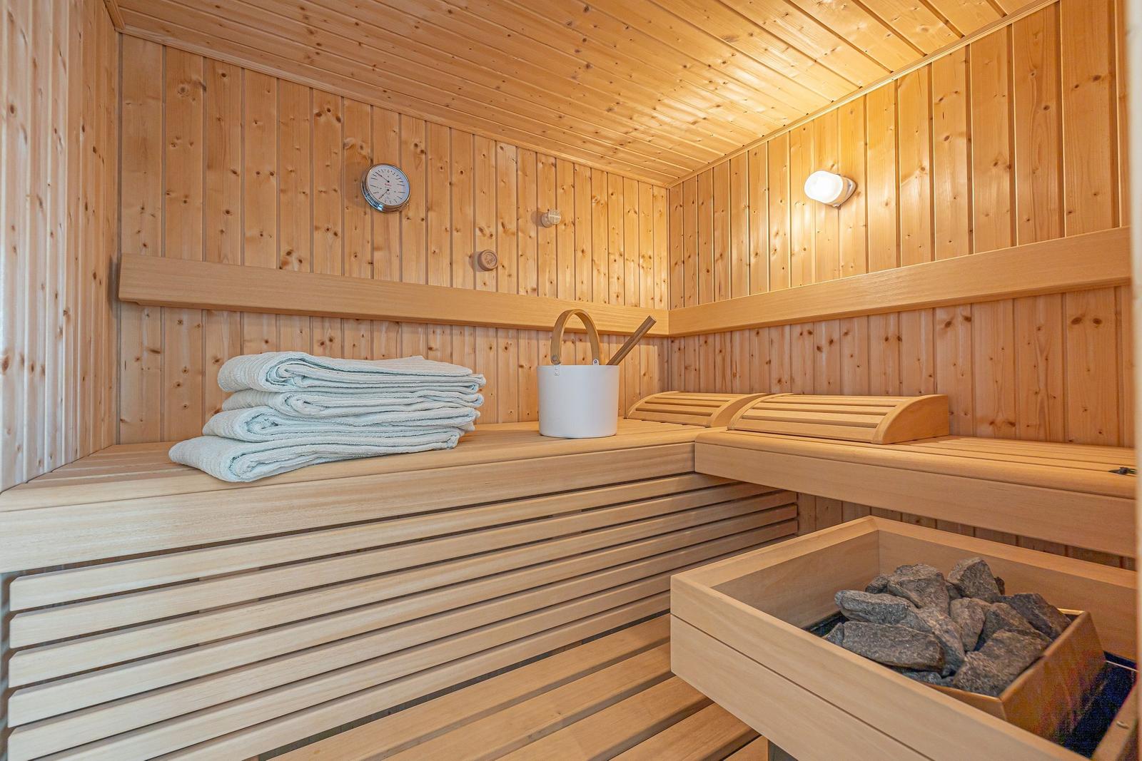 Sauna mit Holzbank, Handtuch und Steinmulde