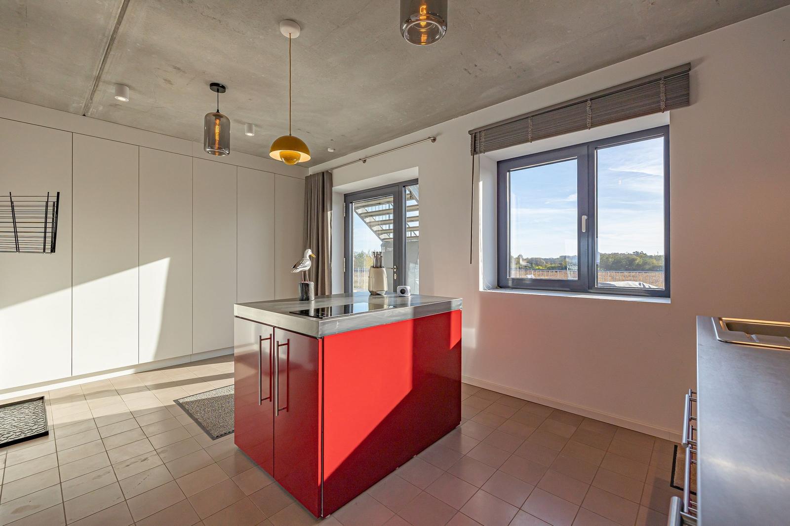Küche mit rotem Inselblock und Fensterblick